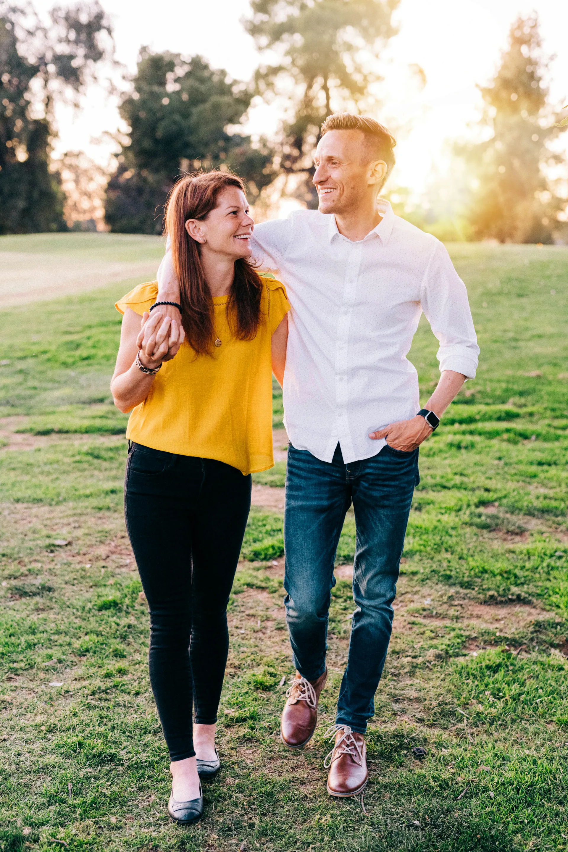 Un homme et une femme d'une trentaine d'années se sourient en marchant dans un parc
