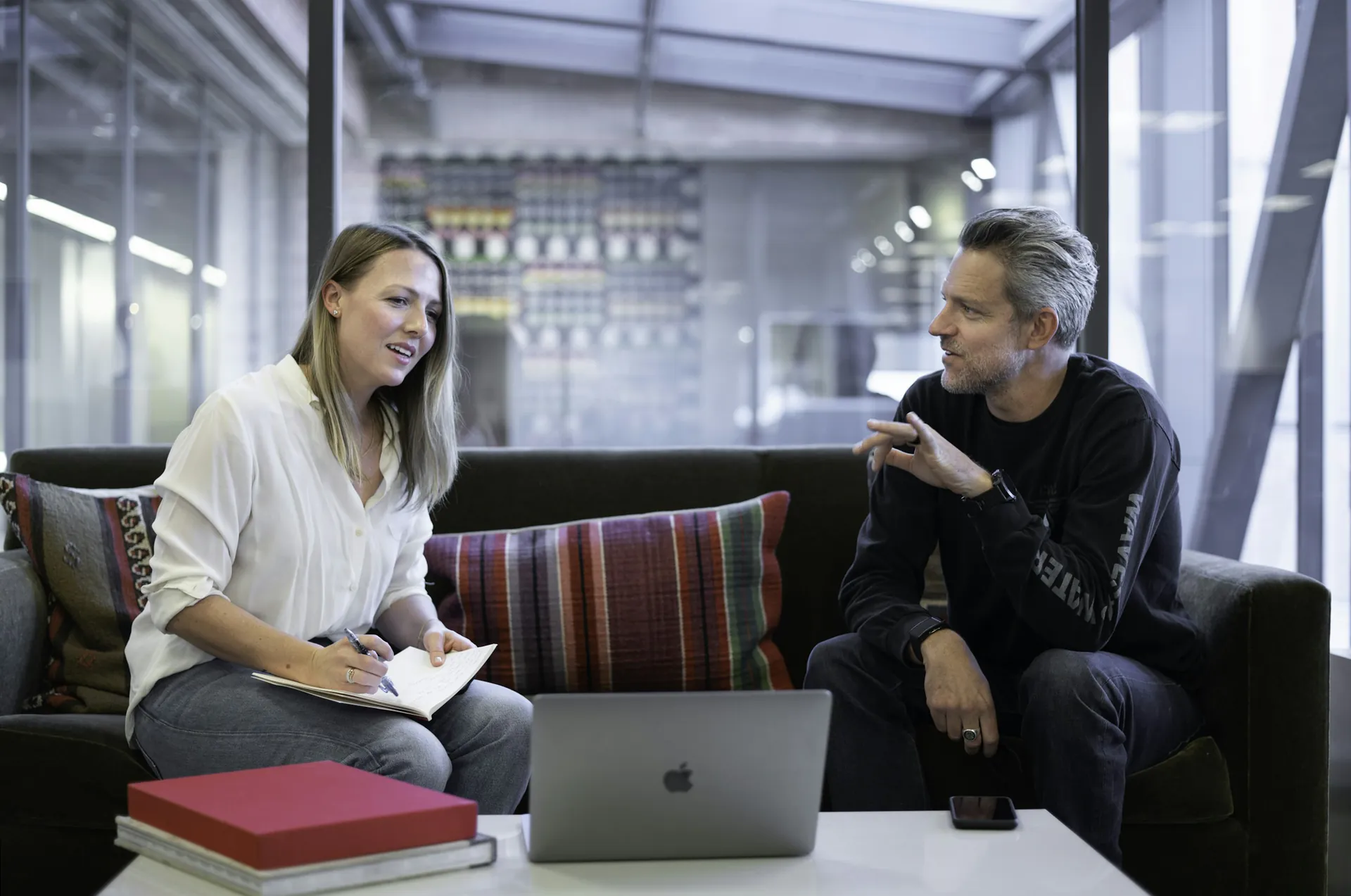 Une ambassadrice, carnet en main, échange avec un adhérent dans un salon